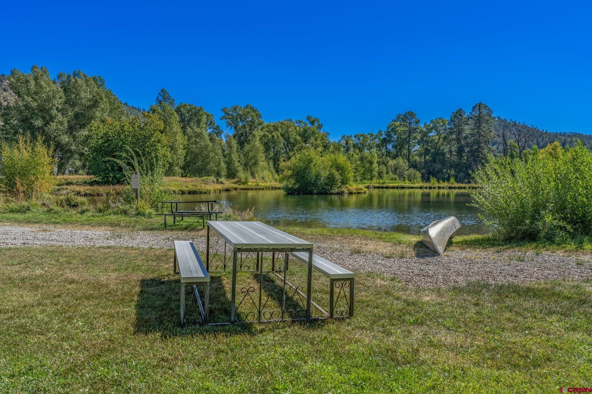 115 Pine River Ranch Circle Bayfield, CO 81122 - Photo 30 of 30 a view of a lake with a bench and lawn chairs