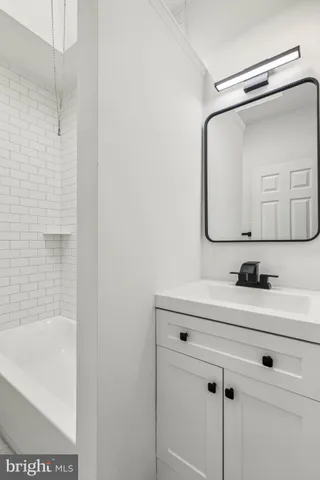 a bathroom with a bathtub a sink a vanity and a mirror