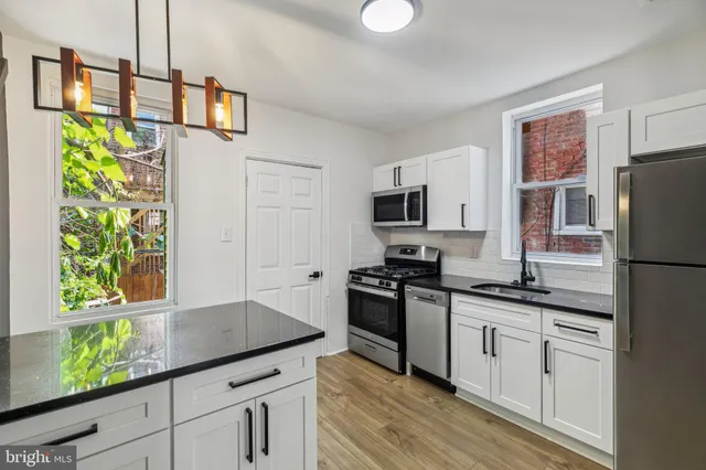 a kitchen with stainless steel appliances granite countertop a stove a sink and a refrigerator