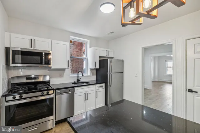 a kitchen with stainless steel appliances a stove microwave and a refrigerator