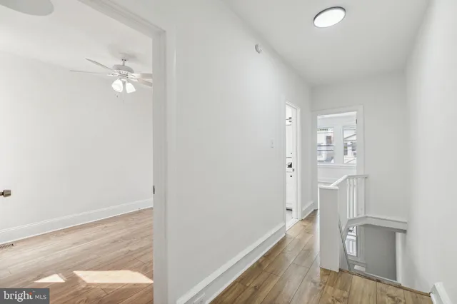 a view of a livingroom with wooden floor and a ceiling fan