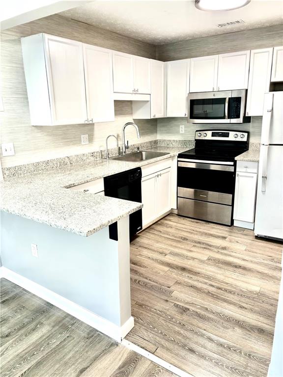 225 Bentley Place Tucker, GA 30084 - Photo 6 of 18 a kitchen with a stove a sink and a microwave