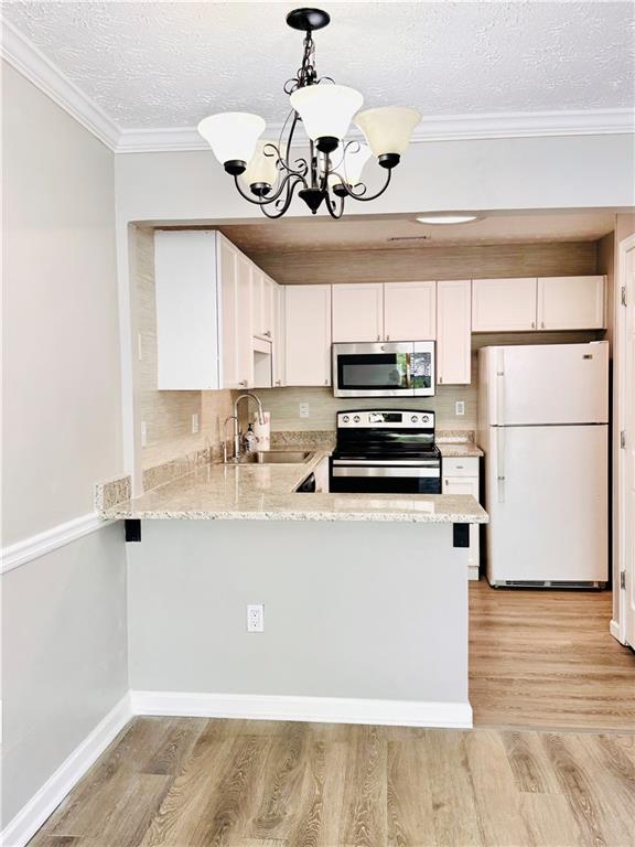 225 Bentley Place Tucker, GA 30084 - Photo 8 of 18 a kitchen with a refrigerator a stove cabinets and wooden floor