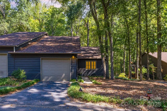 a view of house with backyard and trees