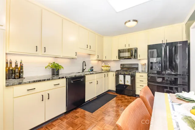 a kitchen with stainless steel appliances kitchen island granite countertop a stove sink and cabinets