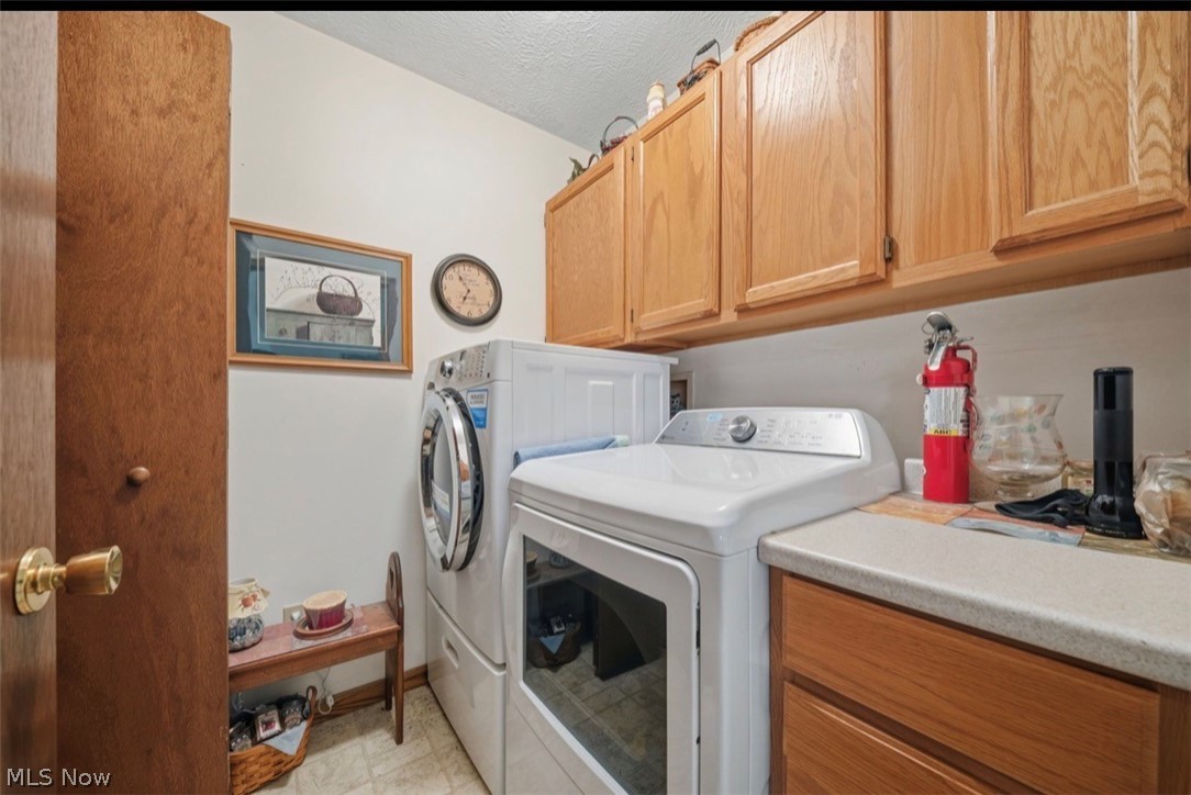 3556 Lake Road Conneaut, OH 44030 - Photo 25 of 39 Dedicated laundry area featuring a countertop, wood-finish cabinetry, and tiled flooring