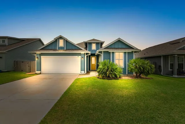 a front view of a house with yard and green space