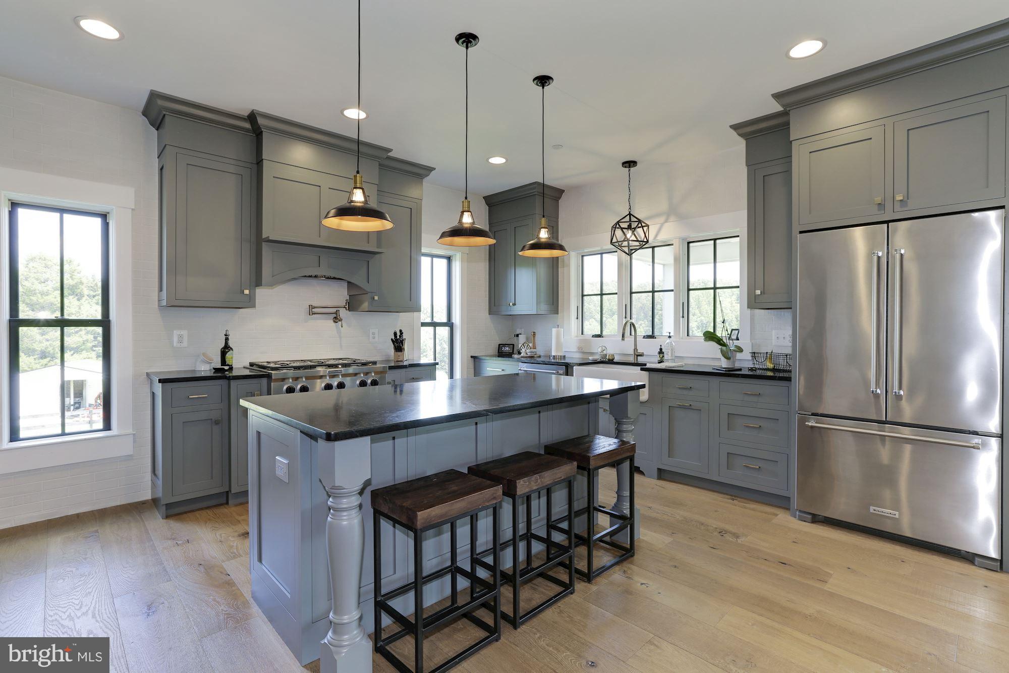254 Friendship Road Tracys Landing, MD 20779 - Photo 12 of 21 a kitchen with stainless steel appliances granite countertop a sink a stove a refrigerator and island with wooden floor
