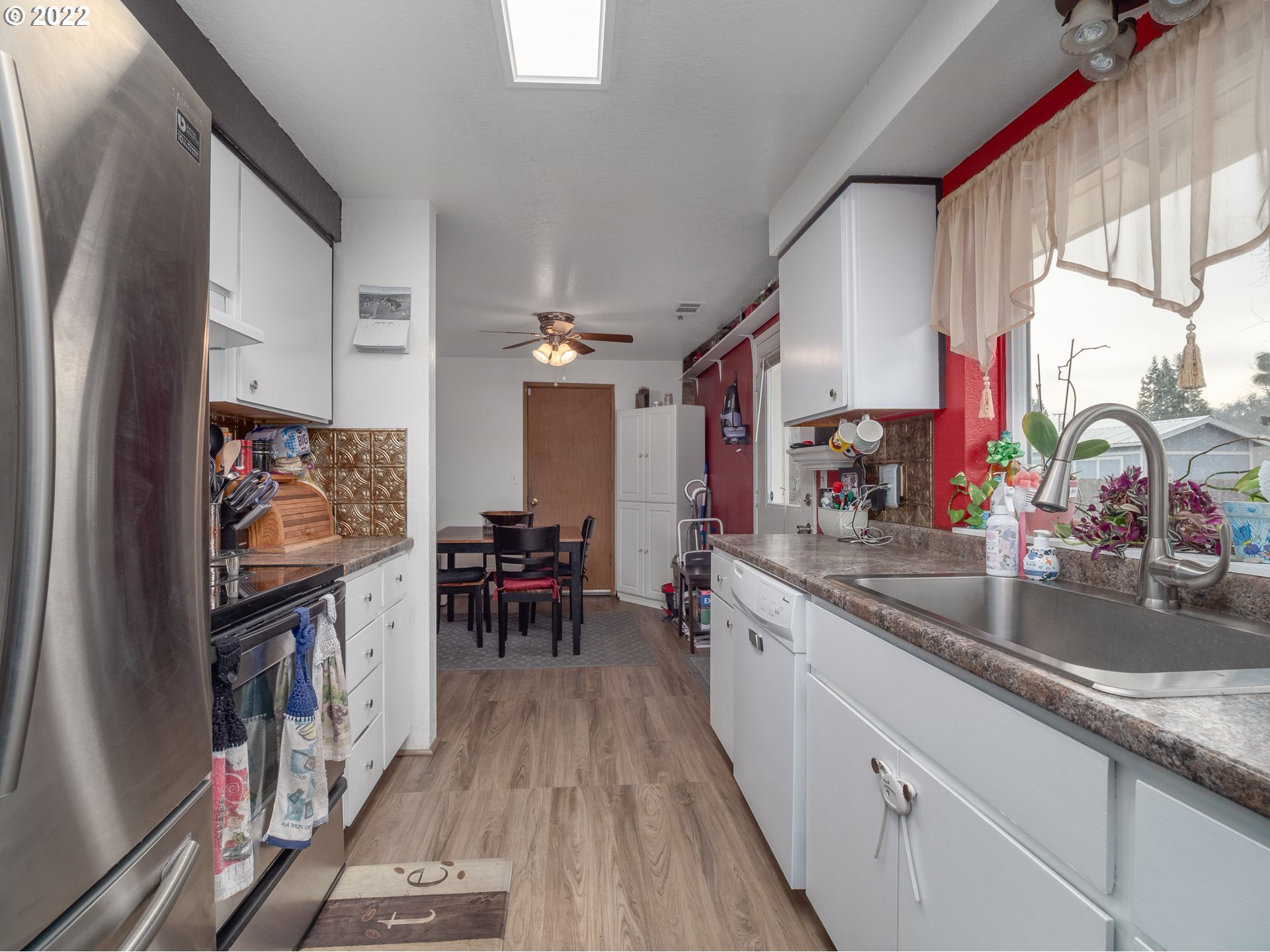 206 Columbia Loop Road Roseburg, OR 97471 - Photo 6 of 24 a kitchen with stainless steel appliances granite countertop a sink dishwasher a microwave oven and a dining table with wooden floor