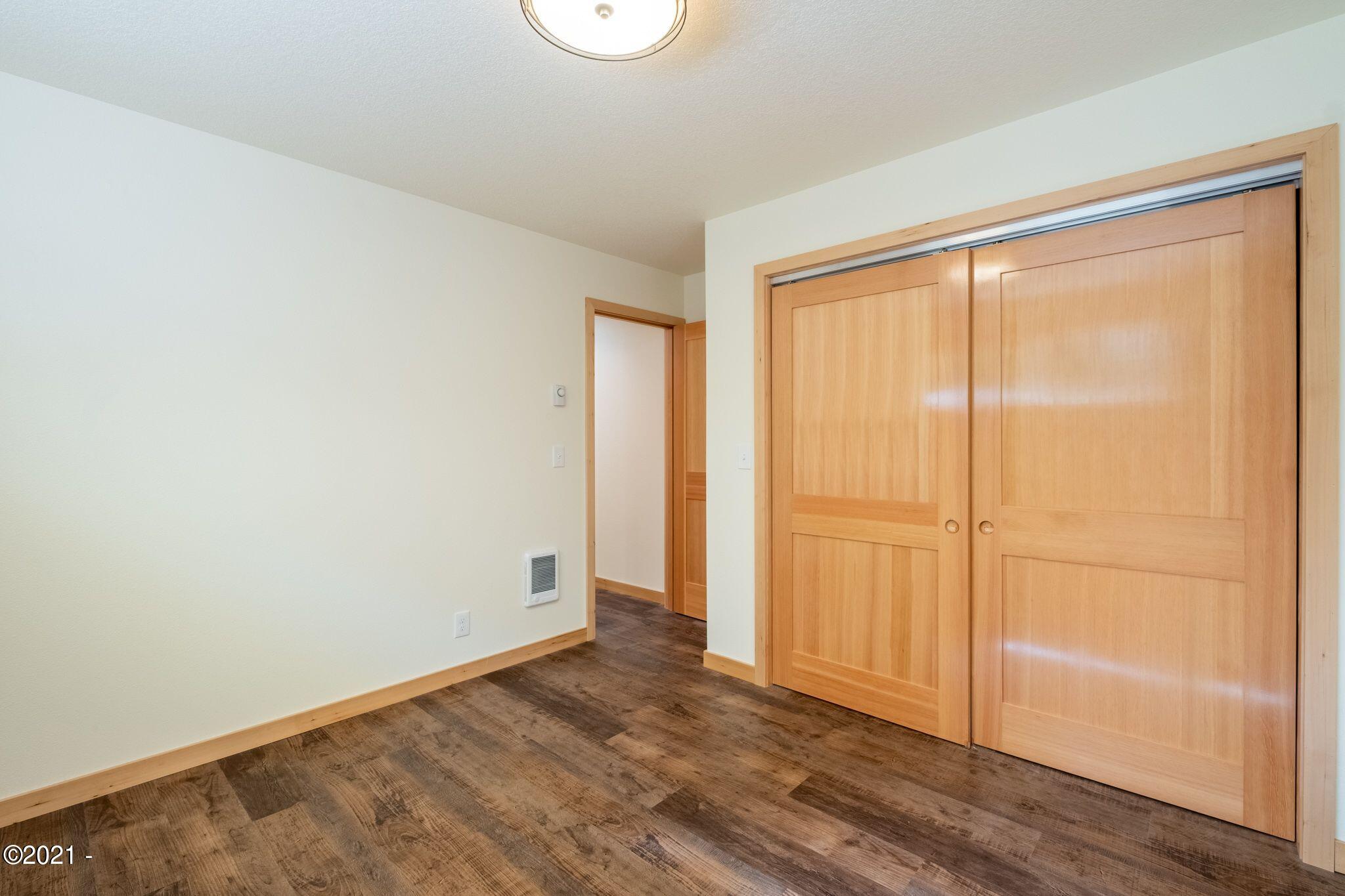 3048 Northeast East Line Road Yachats, OR 97498 - Photo 14 of 31 a view of an empty room with wooden floor and a window