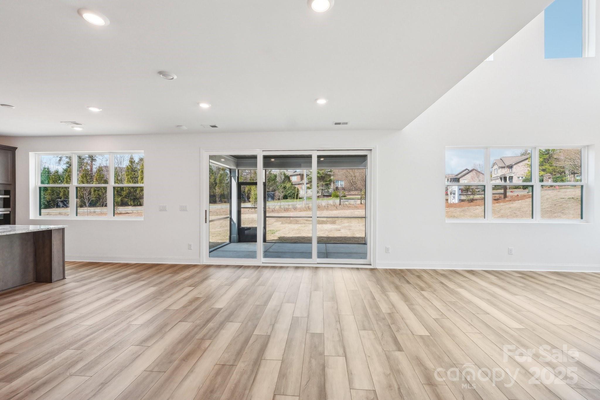 604 Hyder Trail Tega Cay, SC 29708 - Photo 14 of 44 an empty room with wooden floor and windows