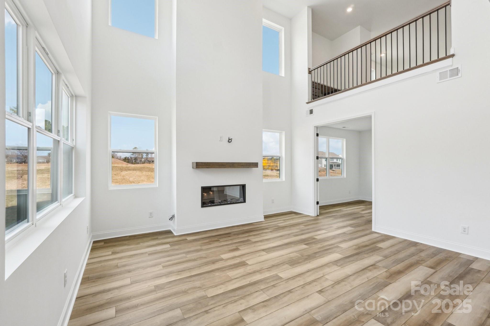 604 Hyder Trail Tega Cay, SC 29708 - Photo 16 of 44 a view of an empty room with wooden floor and a window