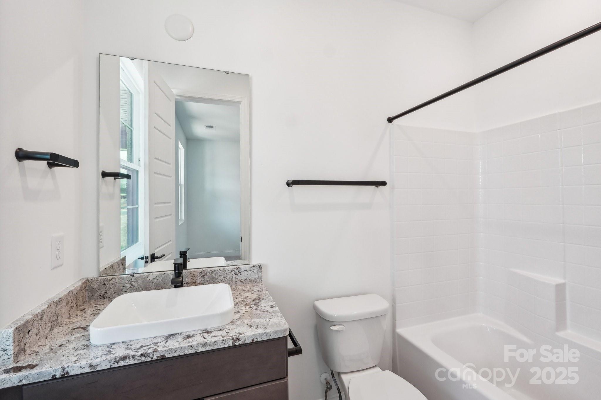 604 Hyder Trail Tega Cay, SC 29708 - Photo 21 of 44 a bathroom with a granite countertop sink a mirror and a toilet
