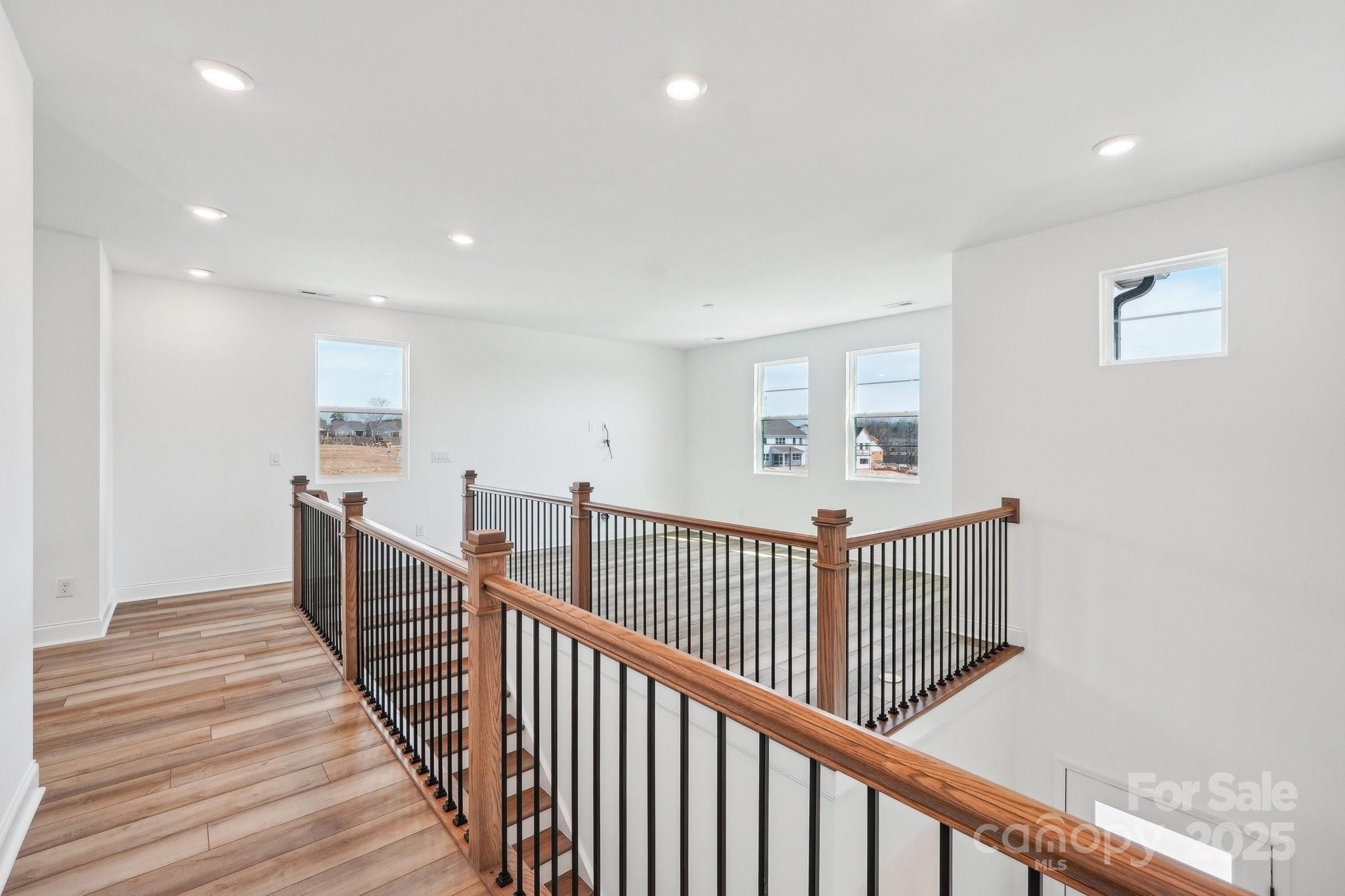 604 Hyder Trail Tega Cay, SC 29708 - Photo 23 of 44 a view of a hallway with wooden floor and windows