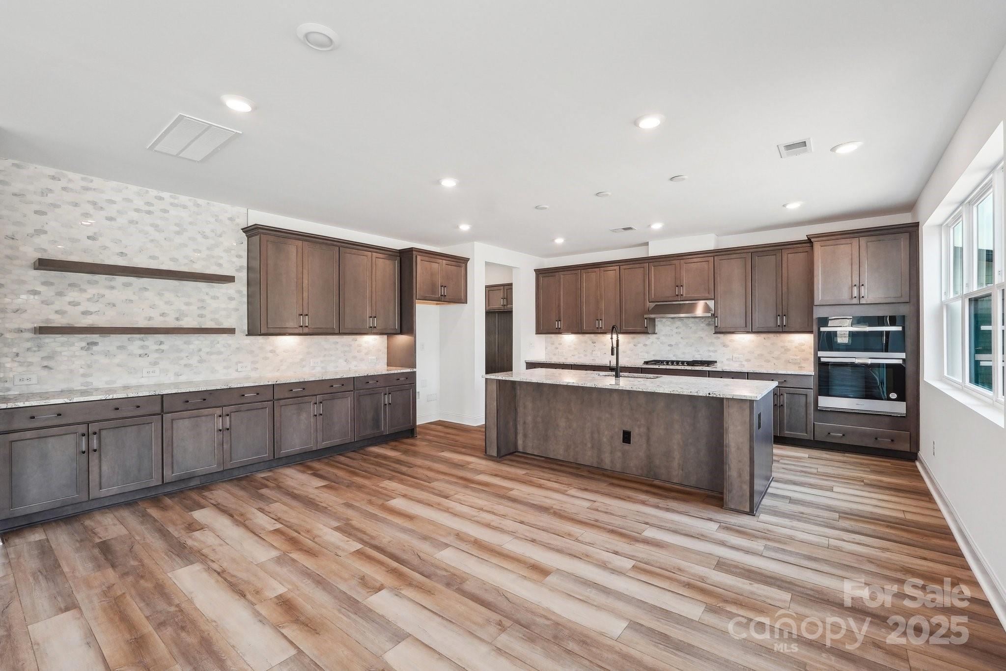 604 Hyder Trail Tega Cay, SC 29708 - Photo 3 of 44 a large kitchen with stainless steel appliances kitchen island a large counter top and a sink