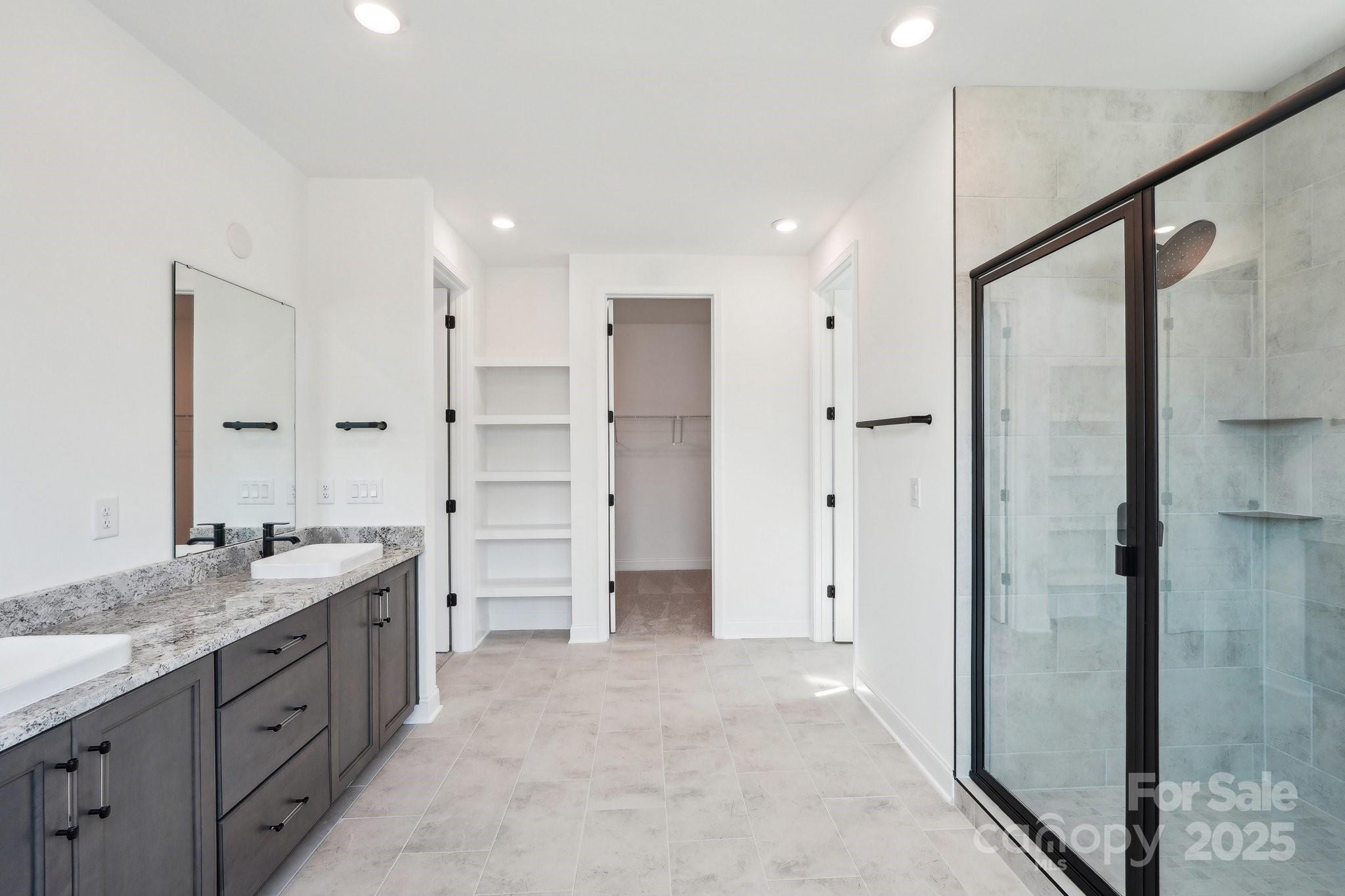 604 Hyder Trail Tega Cay, SC 29708 - Photo 31 of 44 a spacious bathroom with a granite countertop sink mirror and shower
