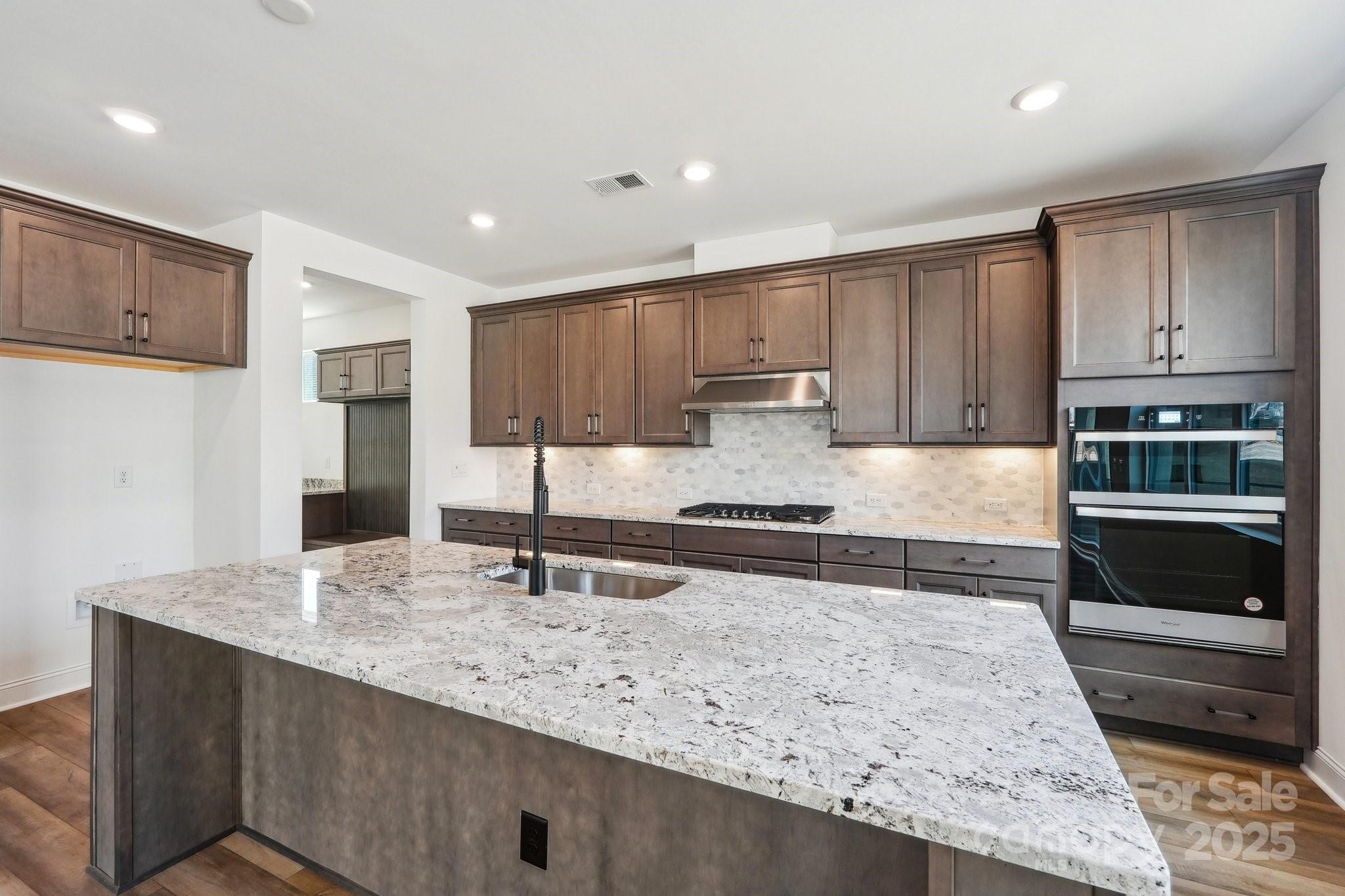604 Hyder Trail Tega Cay, SC 29708 - Photo 8 of 44 a kitchen with stainless steel appliances granite countertop a stove a sink and a microwave