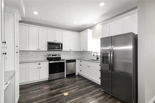 a kitchen with a sink stainless steel appliances and cabinets