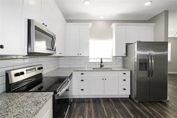 a kitchen with stainless steel appliances granite countertop a stove a sink and a refrigerator