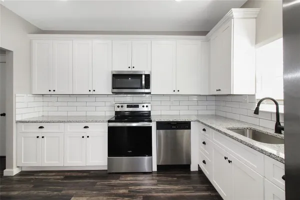 a kitchen with cabinets appliances and a sink