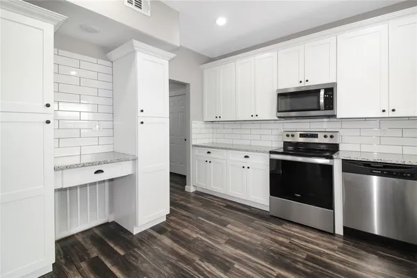 a kitchen with stainless steel appliances a stove a sink and a microwave