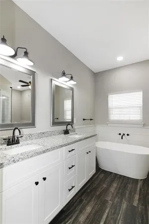 a bathroom with a granite countertop sink mirror and bathtub