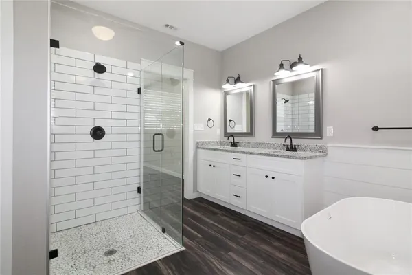 a bathroom with a double vanity sink toilet and shower