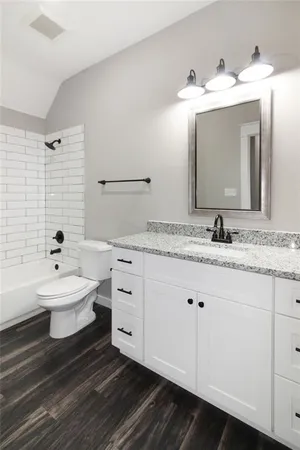 a bathroom with a granite countertop sink mirror and bathtub