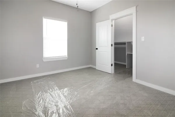 an empty room with windows and closet