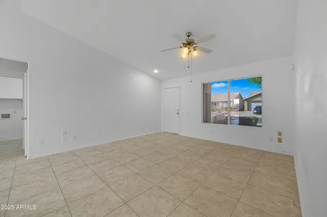 a view of an empty room with a chandelier fan