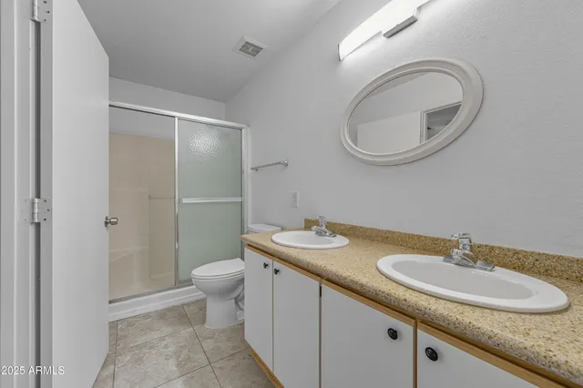 a bathroom with a granite countertop sink a toilet and a mirror