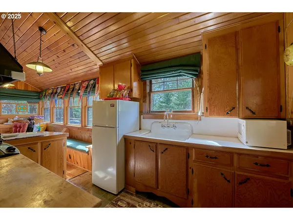 a kitchen with stainless steel appliances granite countertop a sink refrigerator and cabinets