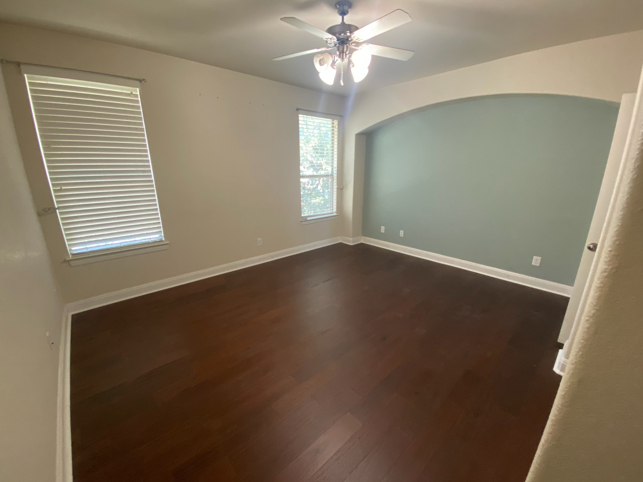 6708 Menchaca Road, Unit 25 Austin, TX 78745 - Photo 4 of 8 Rich hardwood floors and an arched wall alcove highlight this inviting bedroom space.
