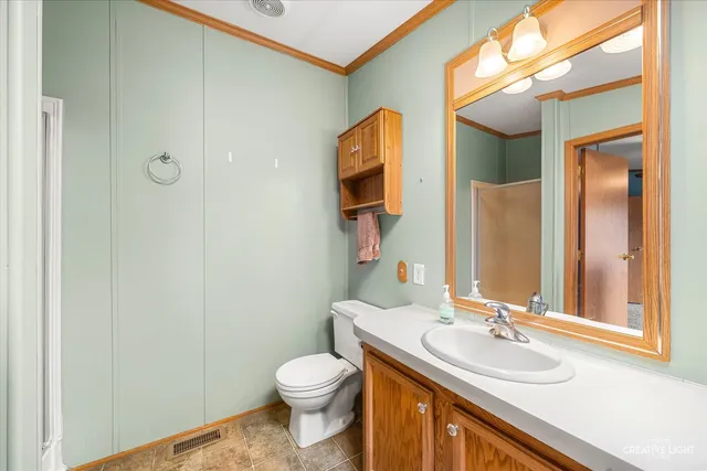 a bathroom with a granite countertop sink toilet and mirror