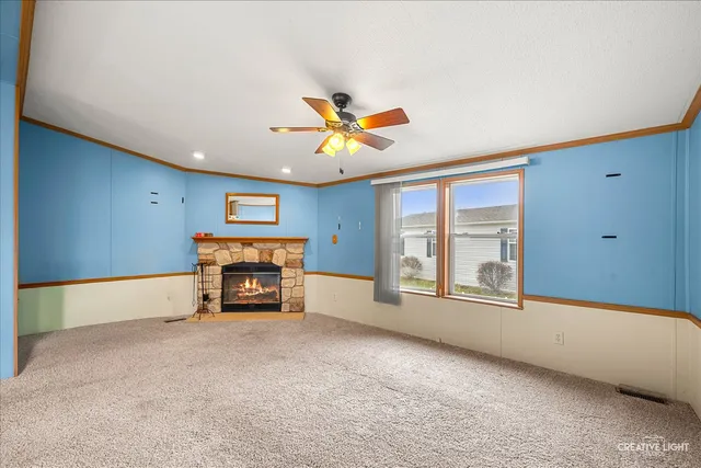 an empty room with windows and fireplace