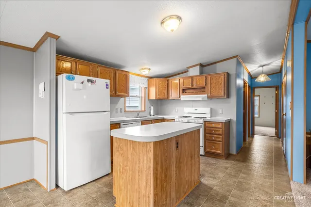 a kitchen with stainless steel appliances granite countertop a refrigerator a sink dishwasher a stove and a refrigerator