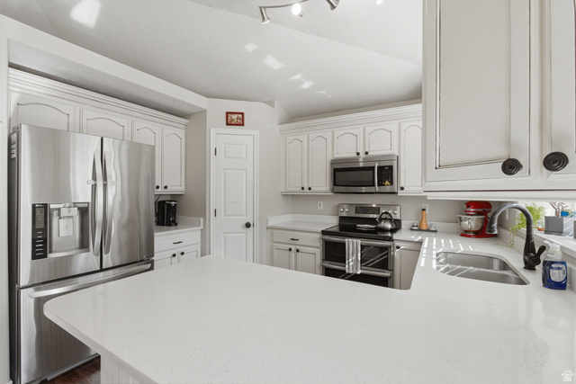 11189 Ohenry Road East Sandy, UT 84070 - Photo 11 of 44 Kitchen featuring white cabinetry with dark hardware, stainless steel French door refrigerator, stainless steel microwave, black electric range with double ovens, and light-toned countertops