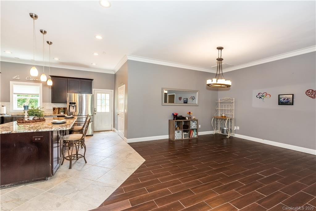 3205 Old Camden Road Monroe, NC 28110 - Photo 14 of 48 a view of a dining room and livingroom with furniture wooden floor a chandelier