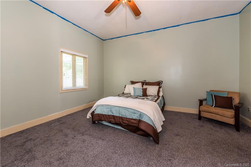 3205 Old Camden Road Monroe, NC 28110 - Photo 22 of 48 a bedroom with a bed and a chandelier