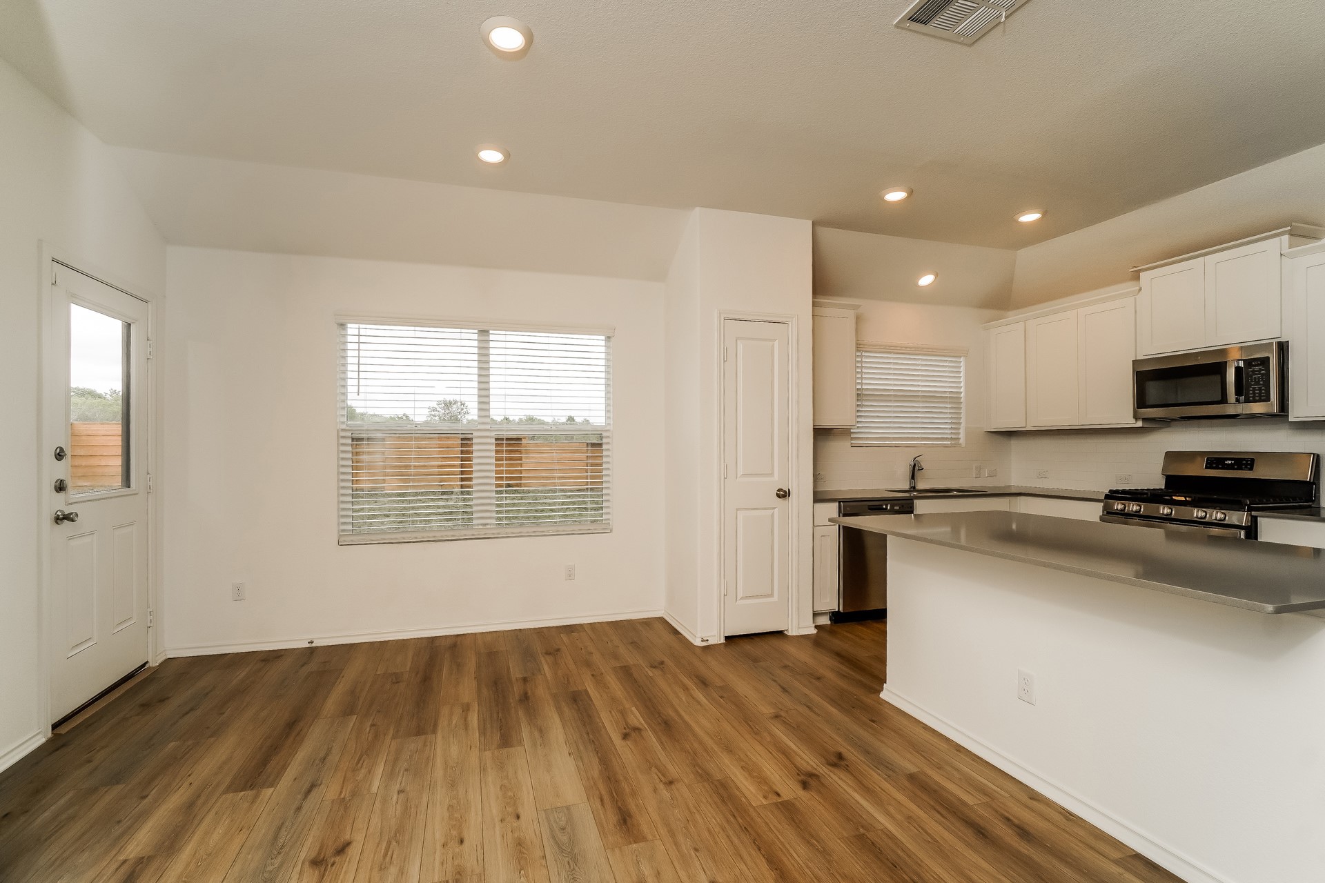 341 Madrid Kyle, TX 78640 - Photo 8 of 27 An open concept kitchen flows seamlessly into the dining area, featuring sleek countertops and modern appliances.