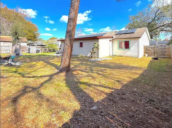 a view of a house with backyard and trees