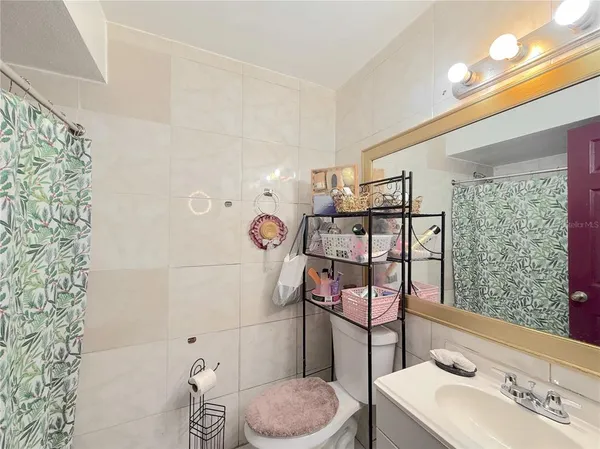 a bathroom with a toilet sink and shower curtain