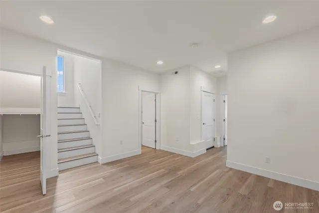 a view of a hallway with stairs and wooden floor
