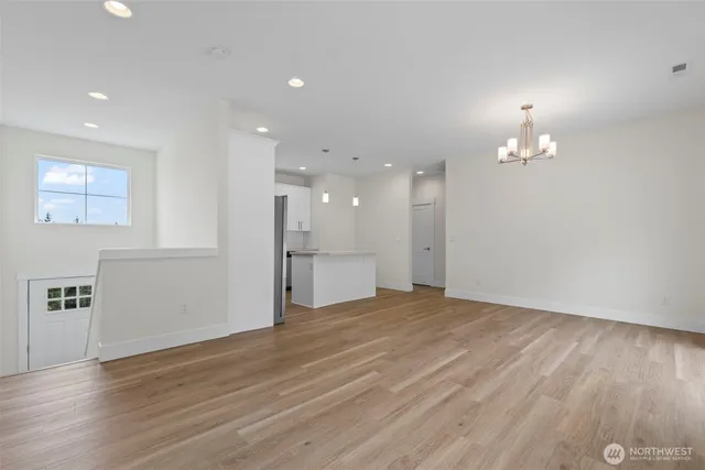 a view of kitchen with kitchen island wooden floor center island and stainless steel appliances