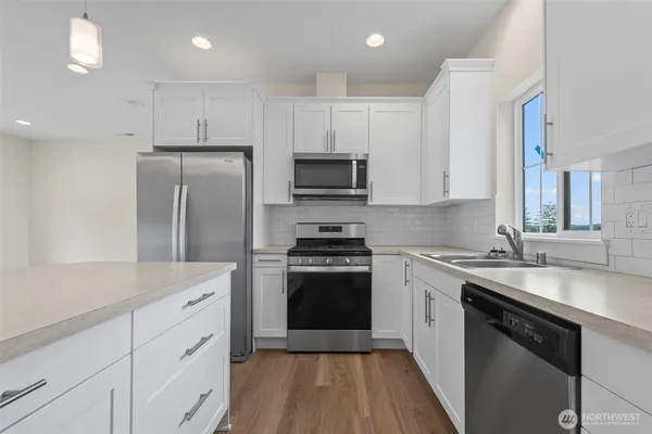 a kitchen with cabinets stainless steel appliances a sink and a stove