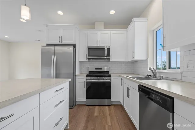 a kitchen with cabinets stainless steel appliances a sink and a stove