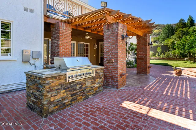 a view of an empty room with wooden floor and a fireplace