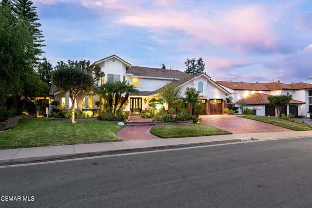 a front view of a house with a yard and garden