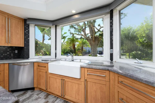 a spacious bathroom with a granite countertop double vanity sink a mirror and a bathtub