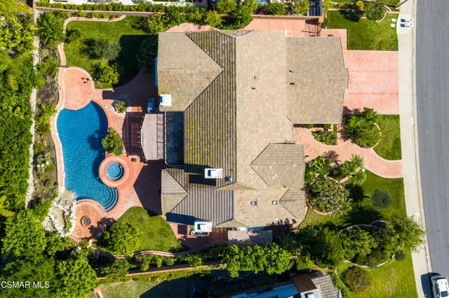 an aerial view of a house with swimming pool and outdoor seating